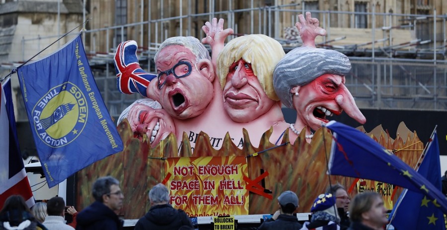 Manifestantes anti-Brexit están parados junto a una camioneta con grandes dibujos animados de destacados políticos británicos que incluyen, de izquierda a derecha, a la primera ministra Theresa May, Boris Johnson, Michael Gove y David Davis, frente al Palacio de Westminster en Londres, el jueves 14 de febrero de 2019. AP Photo/Alastair Grant.