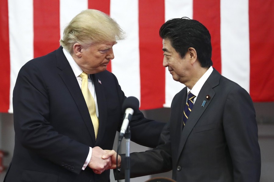 Donald Trump, presidente de Estados Unidos, a la izquierda, le extiende la mano al primer ministro de Japón, Shinzo Abe, durante un discurso ante las tropas japonesas y estadounidenses cuando abordan el helicóptero DDH-184 Kaga de la Fuerza de Autodefensa Marítima de Japón (JMSDF) en la base Yokosuka, al sur de Tokio, el martes 28 de mayo de 2019. Foto AP/Athit Perawongmetha.