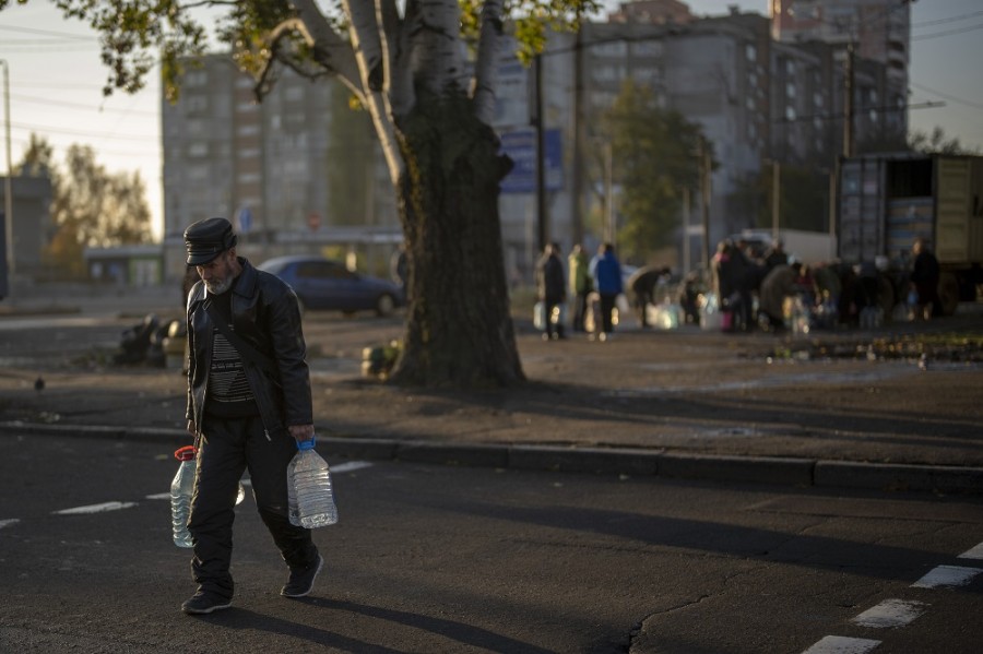 Un hombre lleva botellas de plástico después de volver a llenarlas en un tanque, en el centro de Mykolaiv. Desde mediados de abril, los ciudadanos de Mykolaiv, con una población de medio millón de personas antes de la guerra, han vivido sin suministro de agua luego que Rusia cortó el suministro. Foto AP/Emilio Morenatti