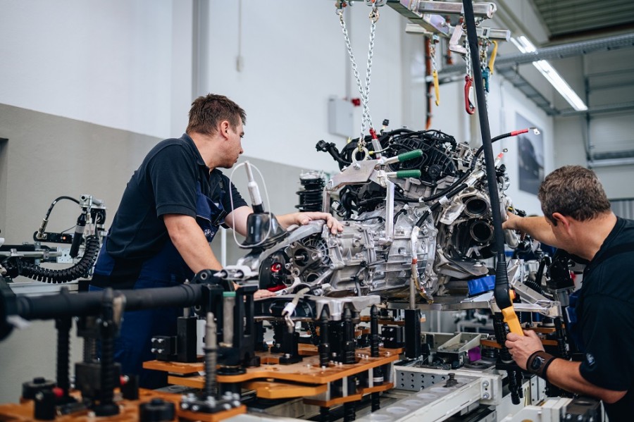 Dos trabajadores de BMW Group trabajan en el ensamble de un motor. Foto de BMV Group