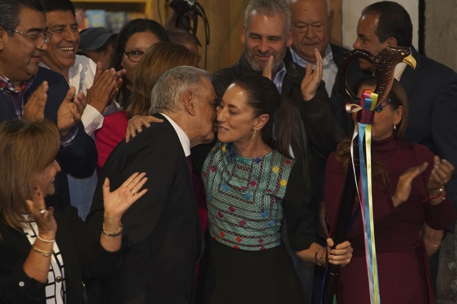 El presidente Andrés Manuel López Obrador besa a la candidata oficial del partido gobernante para las próximas elecciones presidenciales, Claudia Sheinbaum, después de entregarle un bastón de mando durante una ceremonia en el centro de Ciudad de México. Foto AP/Marco Ugarte
