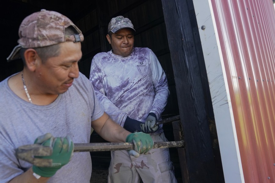 Dos trabajadores originarios de Veracruz realizan labores de mantenimiento en una granja de la localidad de Crofton, Kentucky. Foto AP/Joshua A. Bickel