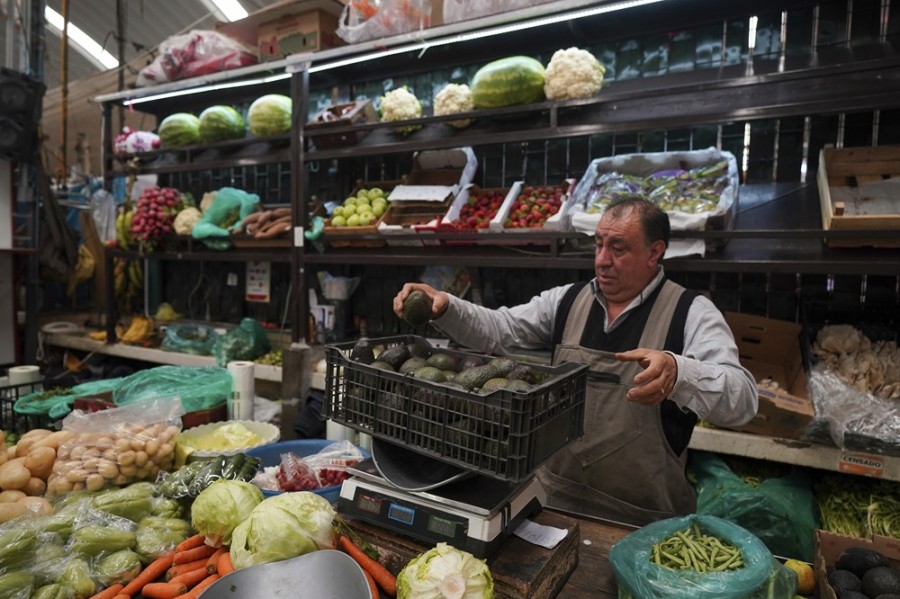Un vendedor carga una caja de aguacates en el Mercado de Medellín, en Ciudad de México. Foto AP/Fernando Llano