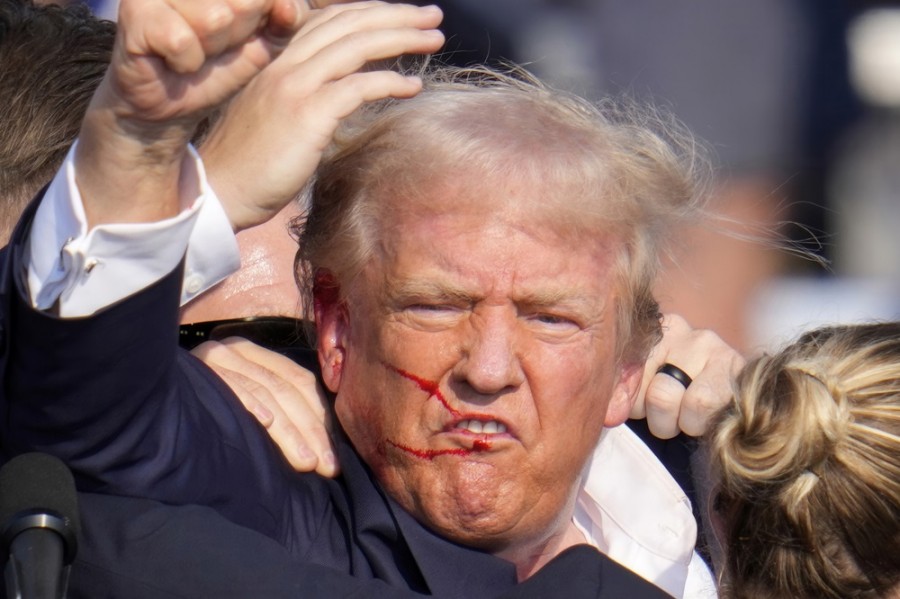 El candidato presidencial republicano, el expresidente Donald Trump, hace gestos mientras está rodeado de agentes del Servicio Secreto de EUA que lo ayudan a bajar del escenario en un mitin de campaña en Butler, Pensilvania, el sábado 13 de julio de 2024. Foto AP/Gene J. Puskar